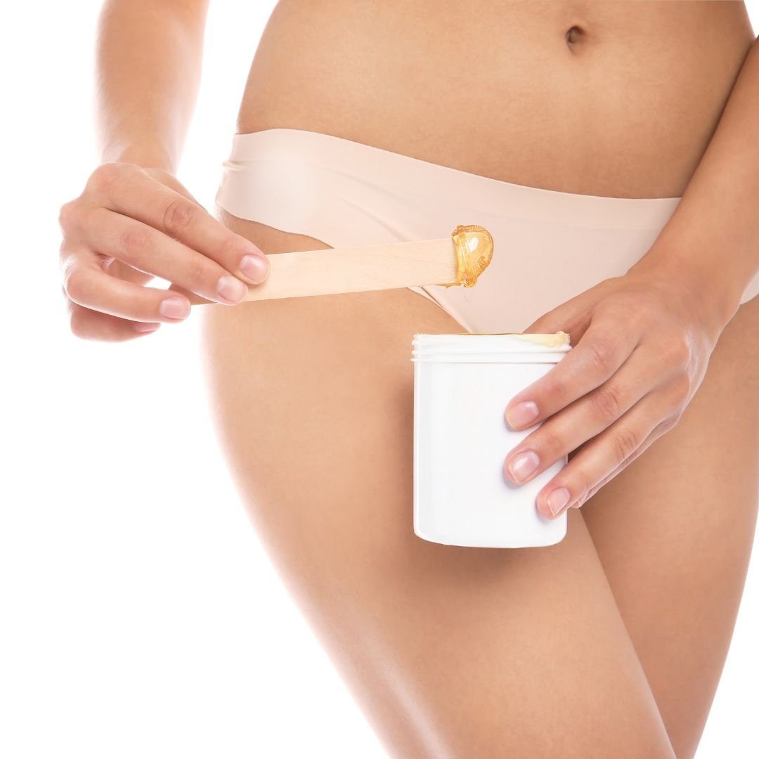 Person in their underwear holding wax near their bikini line.